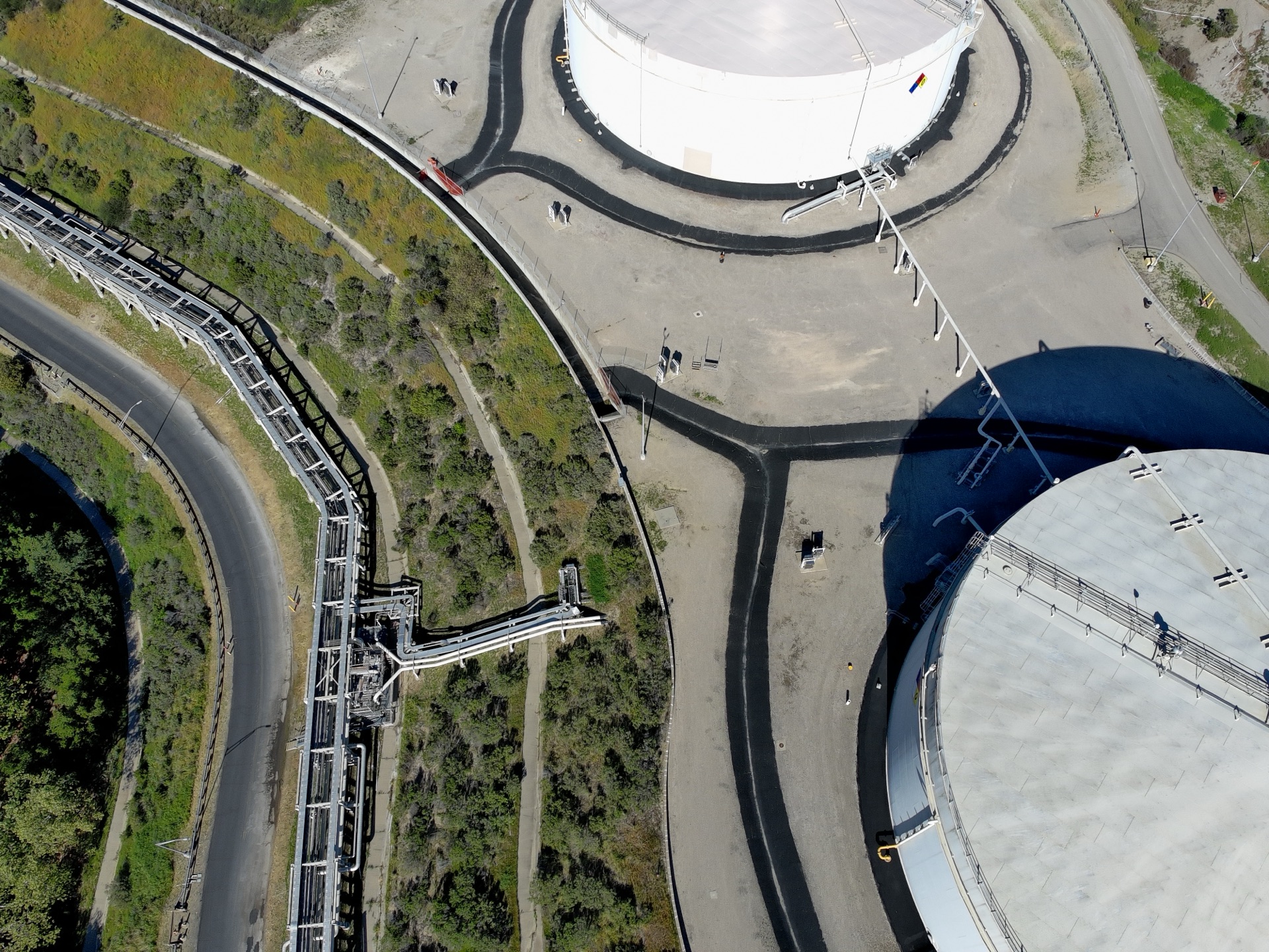 Aerial view of oil and gas facility with storage tanks and pipeline infrastructure